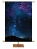 Star-filled night sky with silhouette of distant mountain