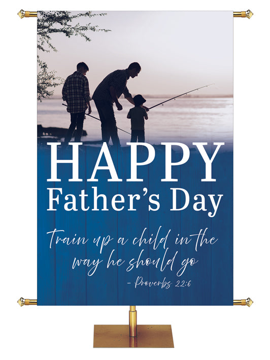 Happy Father's Day Banner. Train up a child in the way he should go Proverbs 22:6 with silhouette on the shoreline of two adults and one teaching a child how to hold the fishing pole
