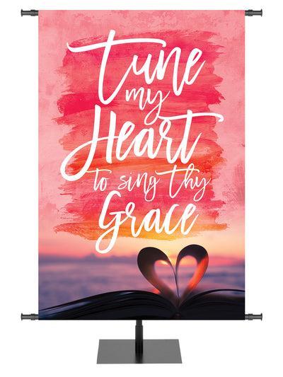 Church Banner with pastel heart and sunrise over ocean and verse Tune my Heart to sing Thy Grace